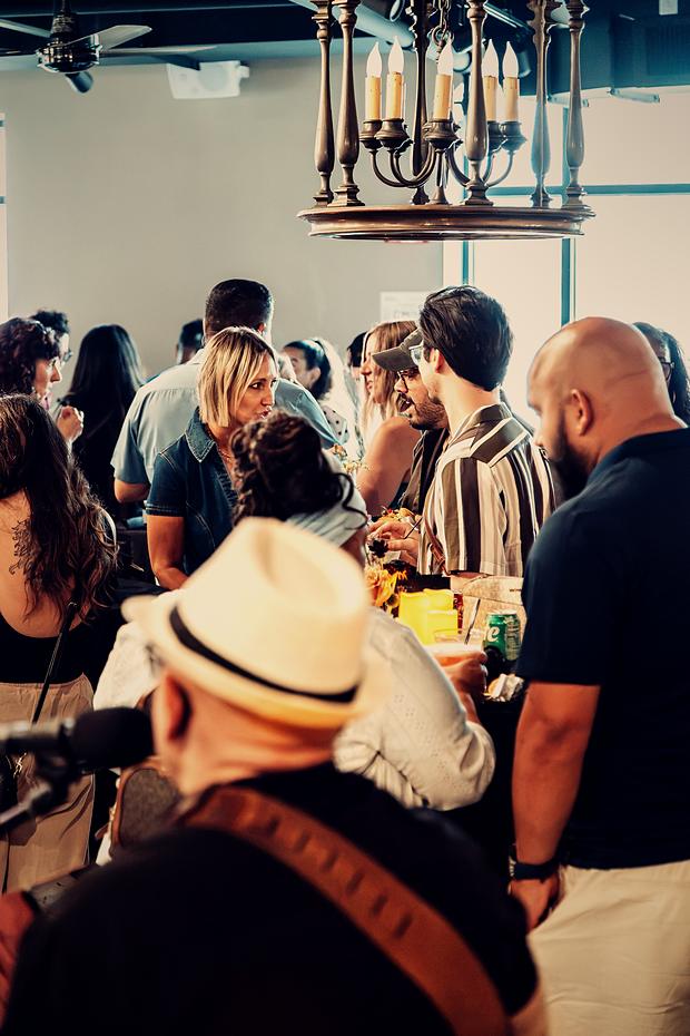 Guests packed in around the bar, a panama hat in the foreground.