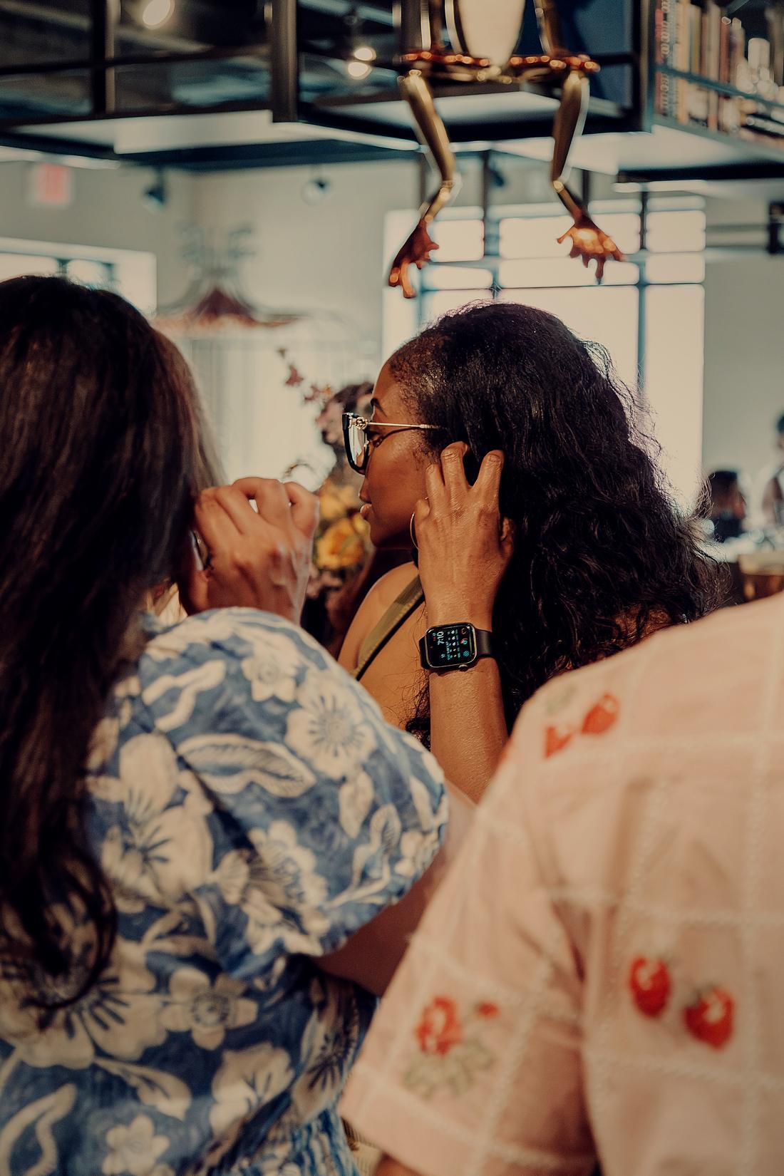 Two guests greeting each other, a hand to the cheek.