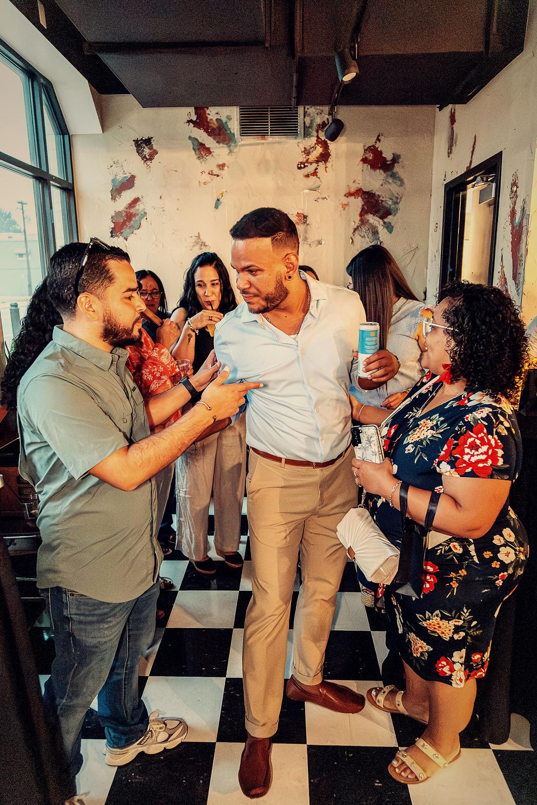 A group laughing together with drinks in hand.